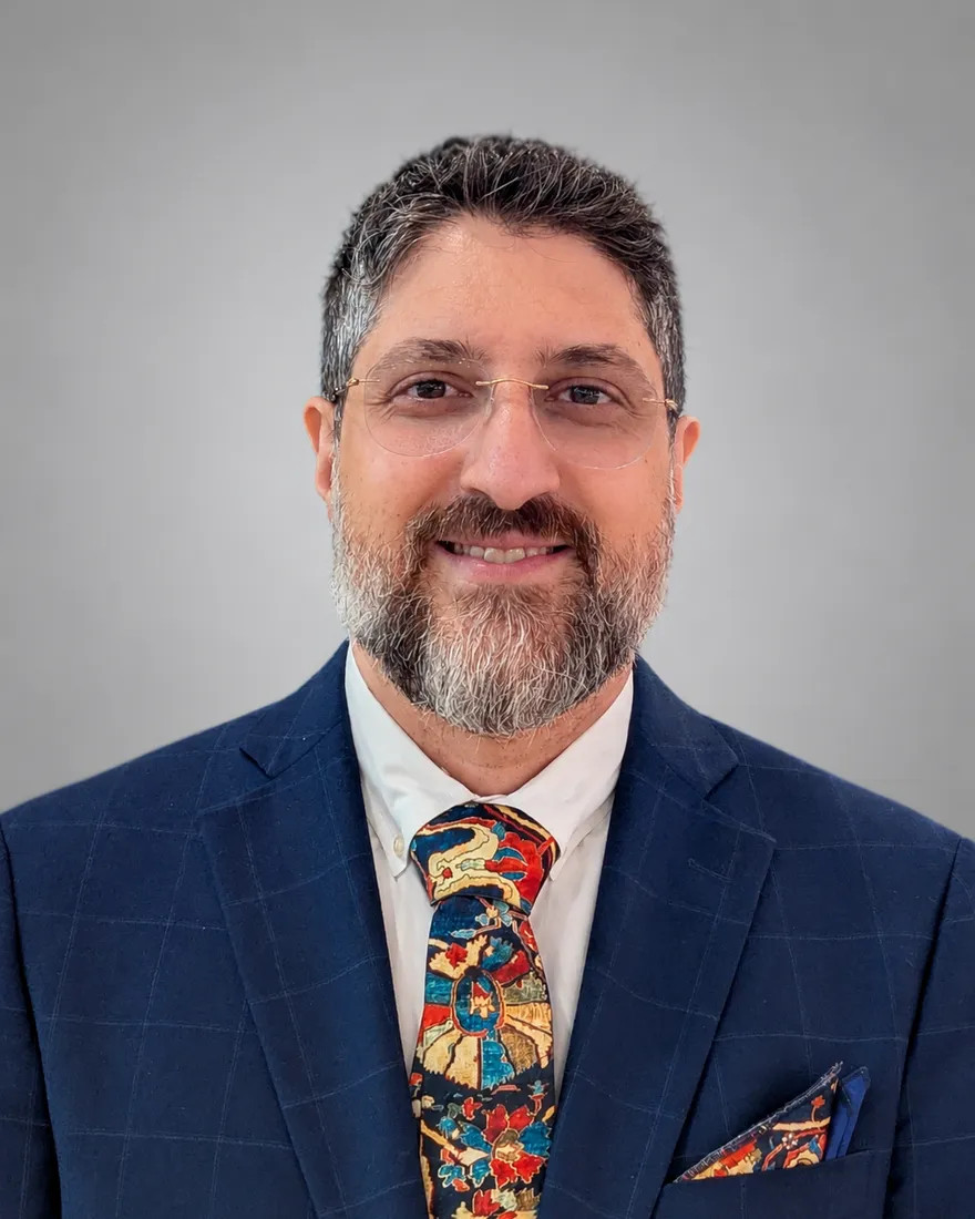 Dr. Mohammad Keyhani wearing a navy suit and patterned tie